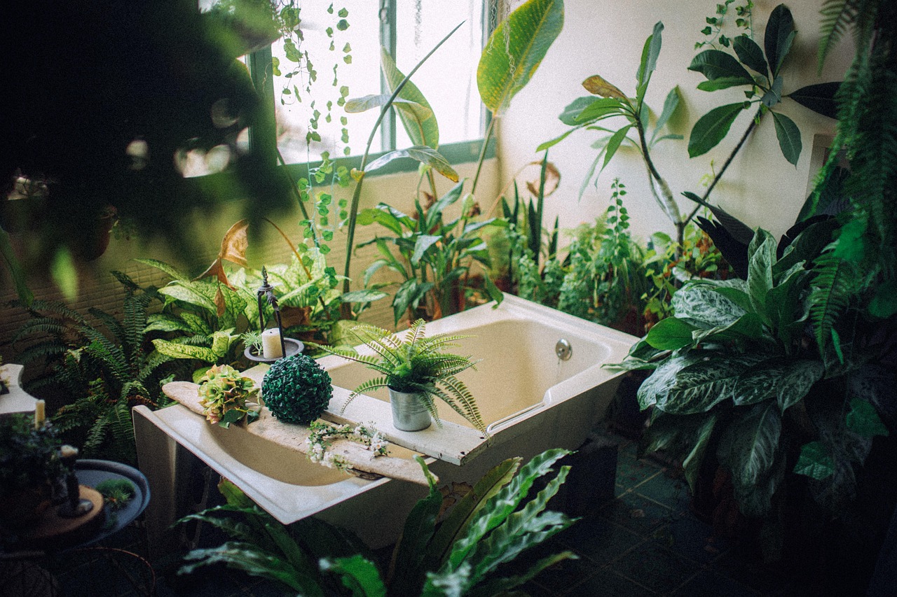 White freestanding soaking tub beside a large window