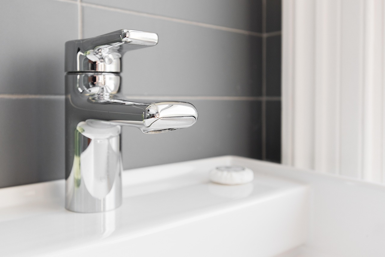 Modern brushed faucet over a white bathroom sink
